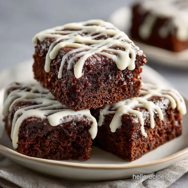 A fudgy football brownie on a white plate, showing the moist, dense texture with its glossy chocolate frosting.